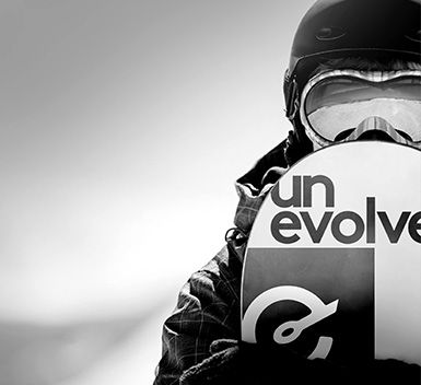 a black and white close up of a snowboarder outside holding his snowboard